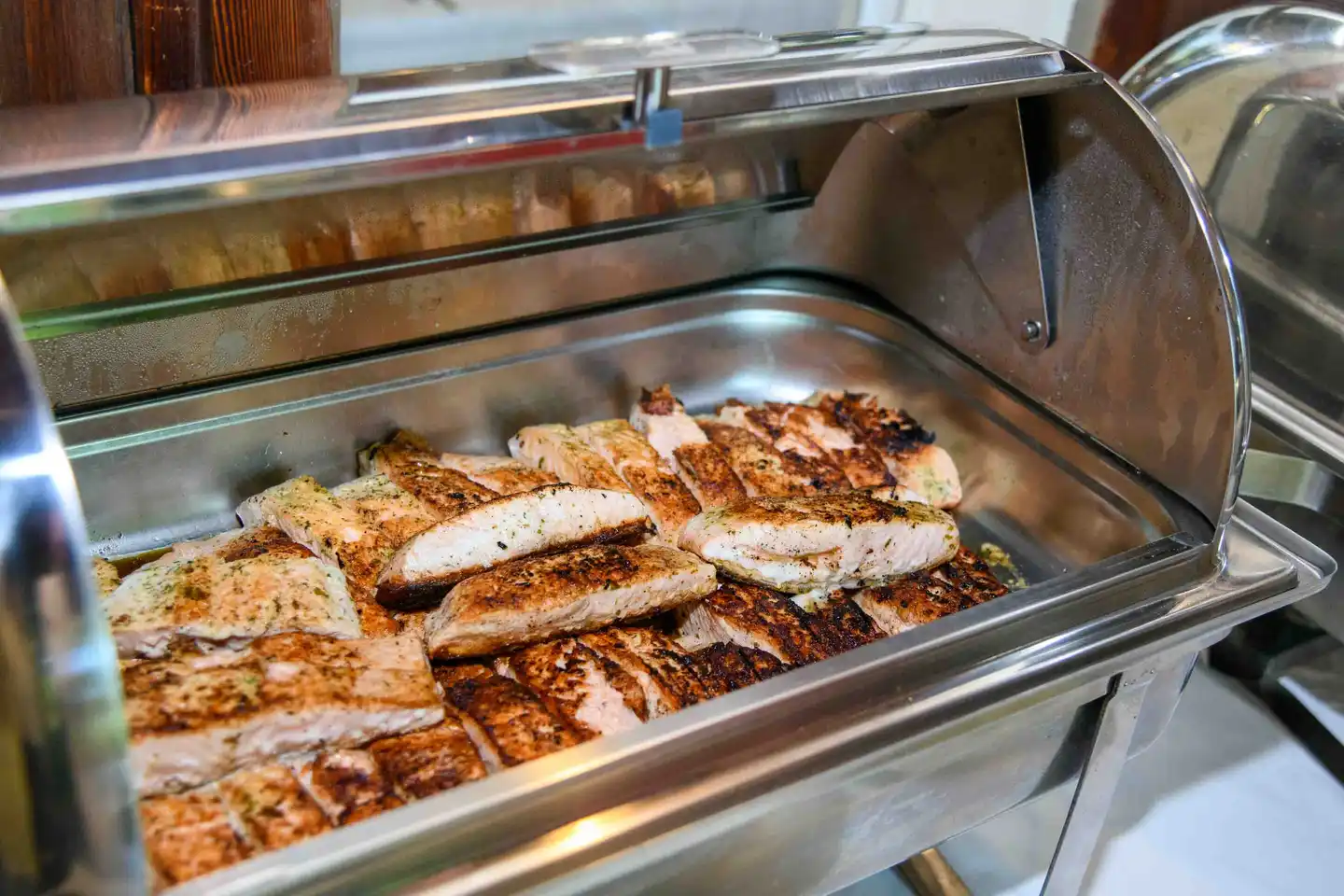 Chafing Dish mit gegrillten Lachsfilets am Buffet des Firmensommerfests in Wien