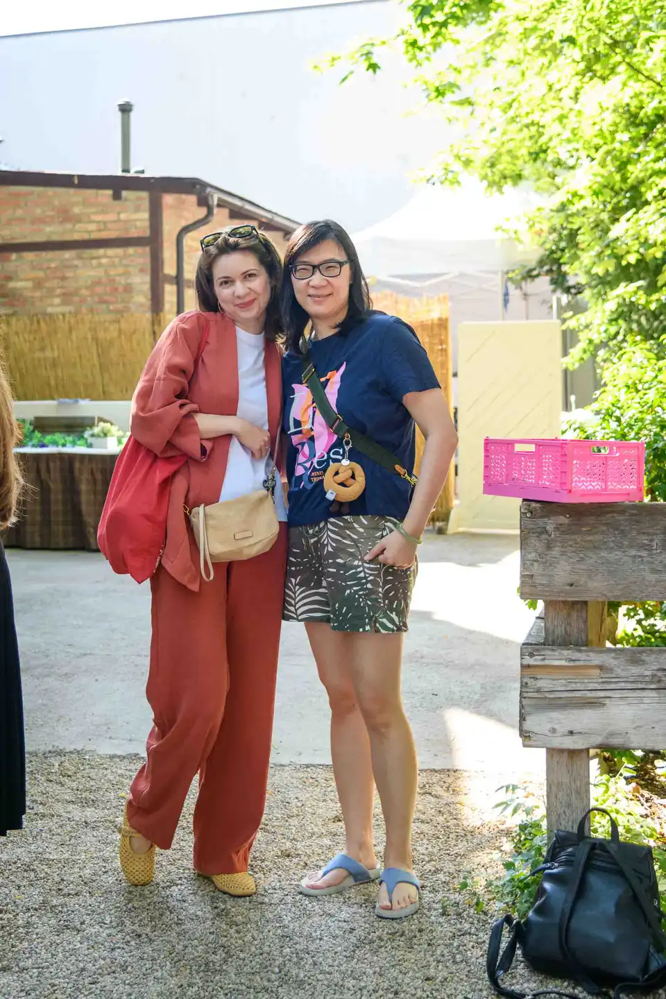 Zwei Kolleginnen posieren Arm in Arm im Innenhof des Lokals – Sommerfest Eventfotografie Wien