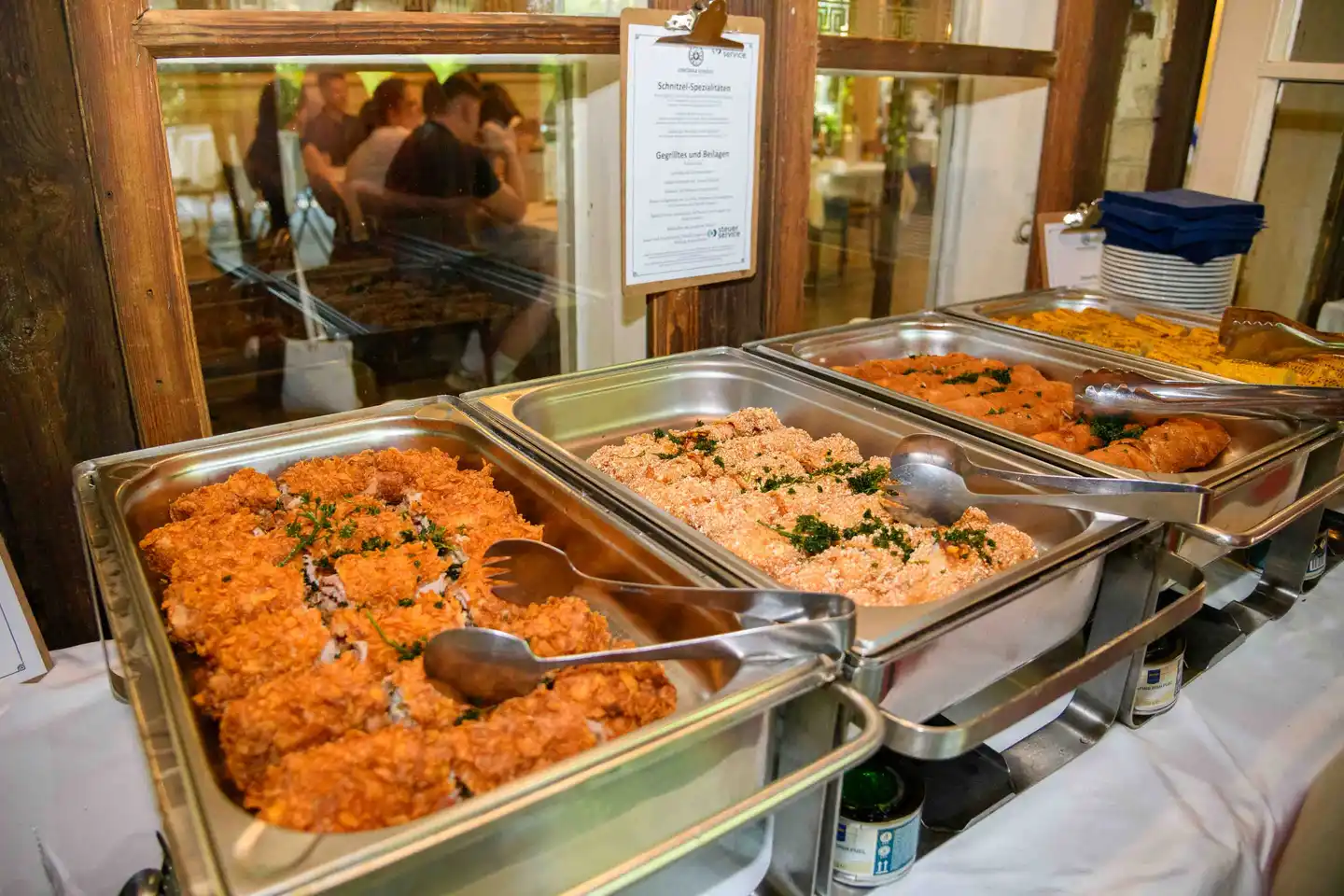 Chafing Dishes mit panierten Schnitzeln und Menükarte Schnitzel-Spezialitäten – Sommerfest Wien