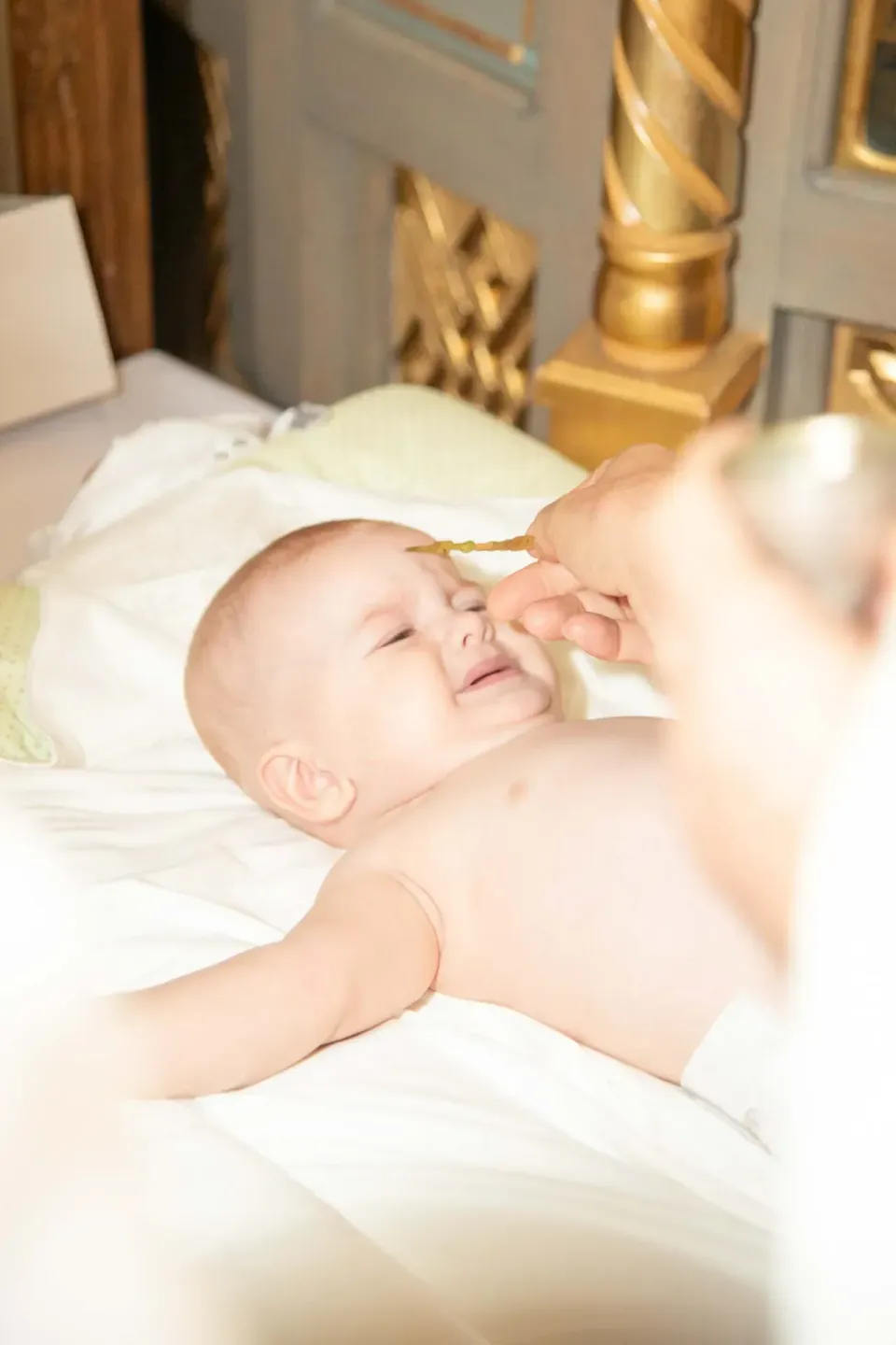 Baby bei der Taufe mit goldenem Taufkreuz, professionelle Eventfotografie Wien