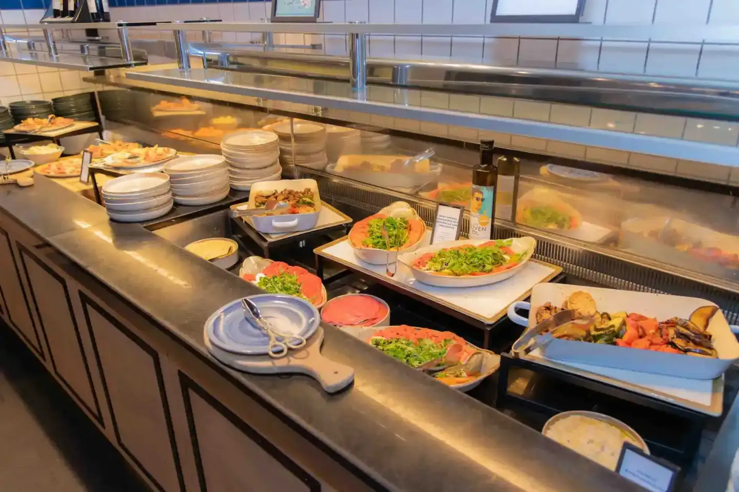 Buffet mit frischen Salaten, gegrilltem Gemüse und Tellern bei Firmenevent Wien