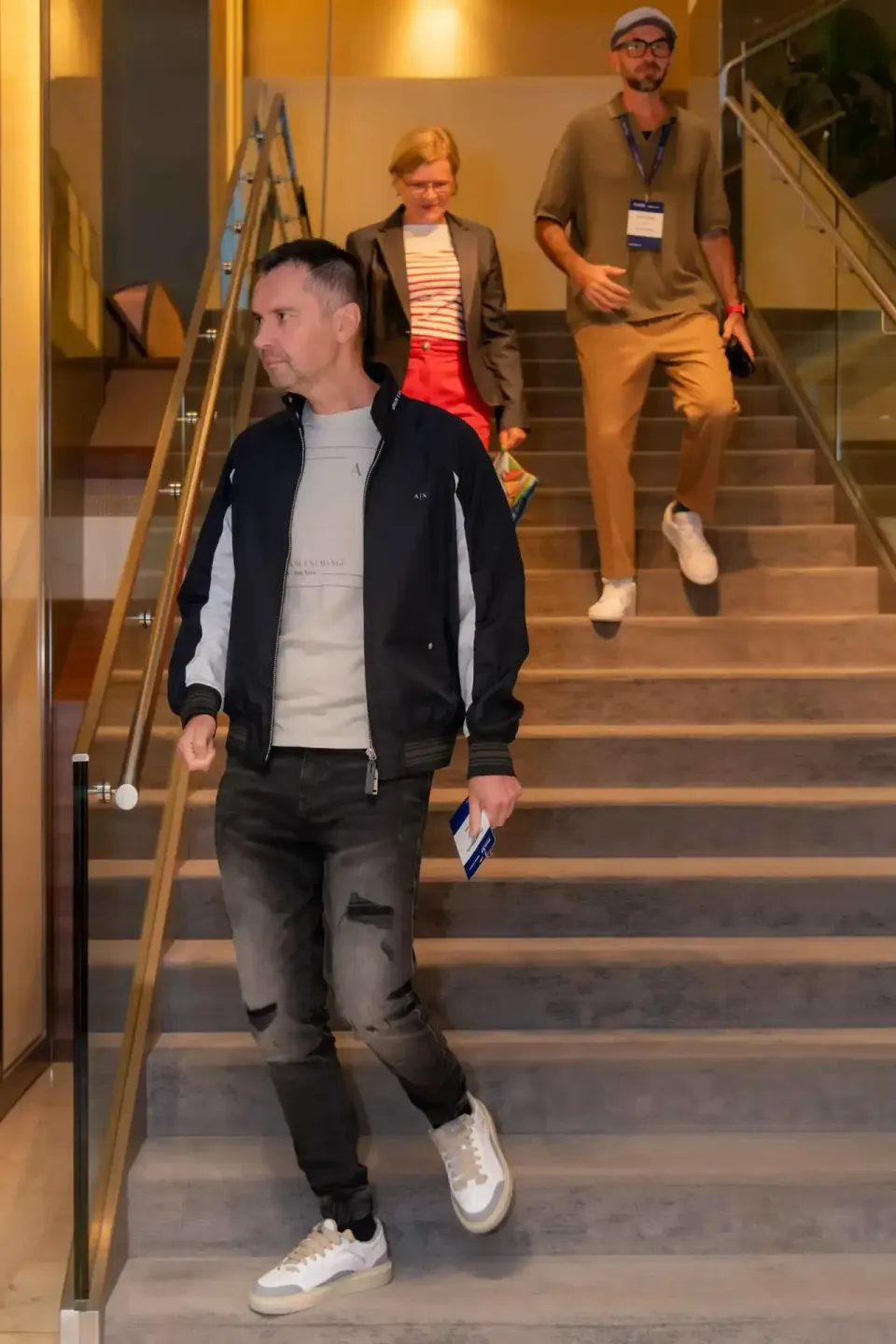 Eventfotograf Wien dokumentiert Teilnehmer beim Hinabgehen einer modernen Treppe während eines Firmenevent