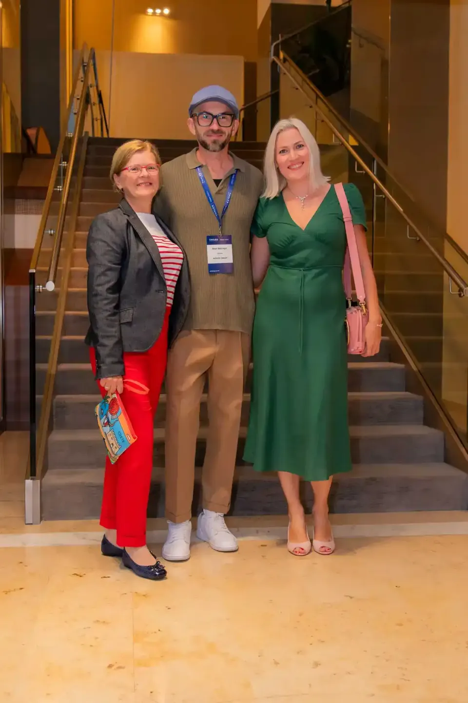 Drei Personen posieren vor einer Treppe bei einem Firmenevent – professionelle Eventfotografie Wien