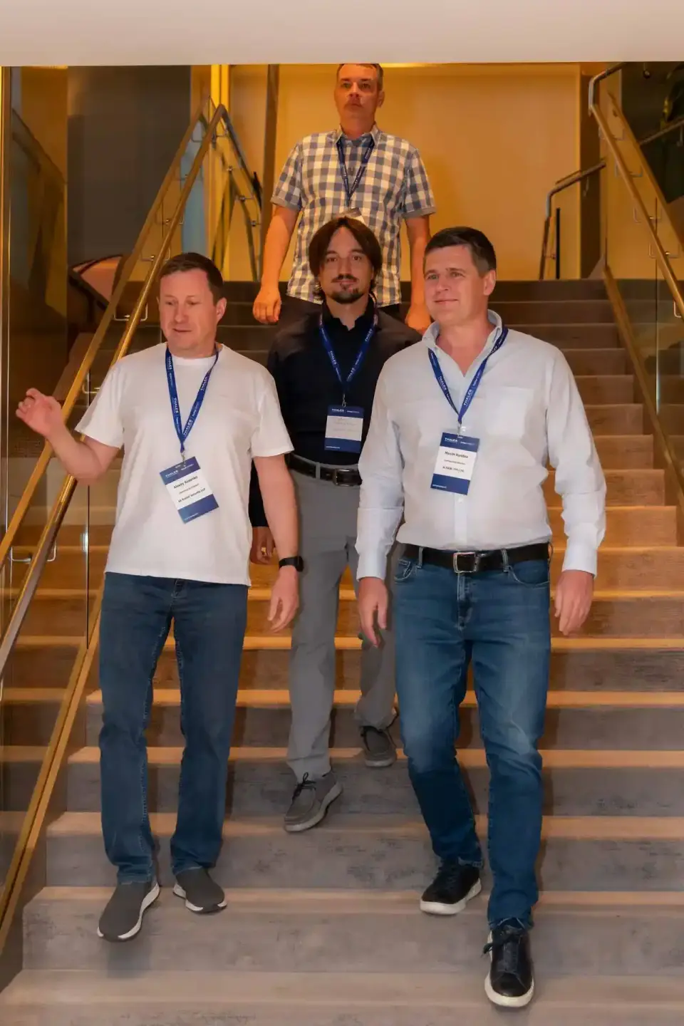 Vier Männer mit Badges auf einer Treppe bei einem Firmenevent Wien, professionelle Eventfotografie