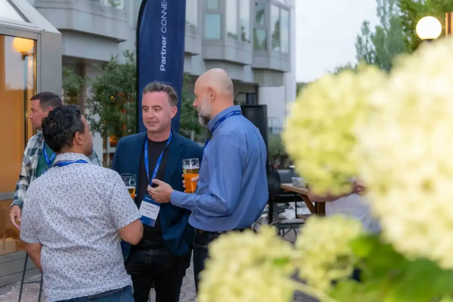 Eventfotograf Wien dokumentiert Geschäftsgespräche beim Thales Firmenevent in entspannter Atmosphäre mit Getränken und grüner