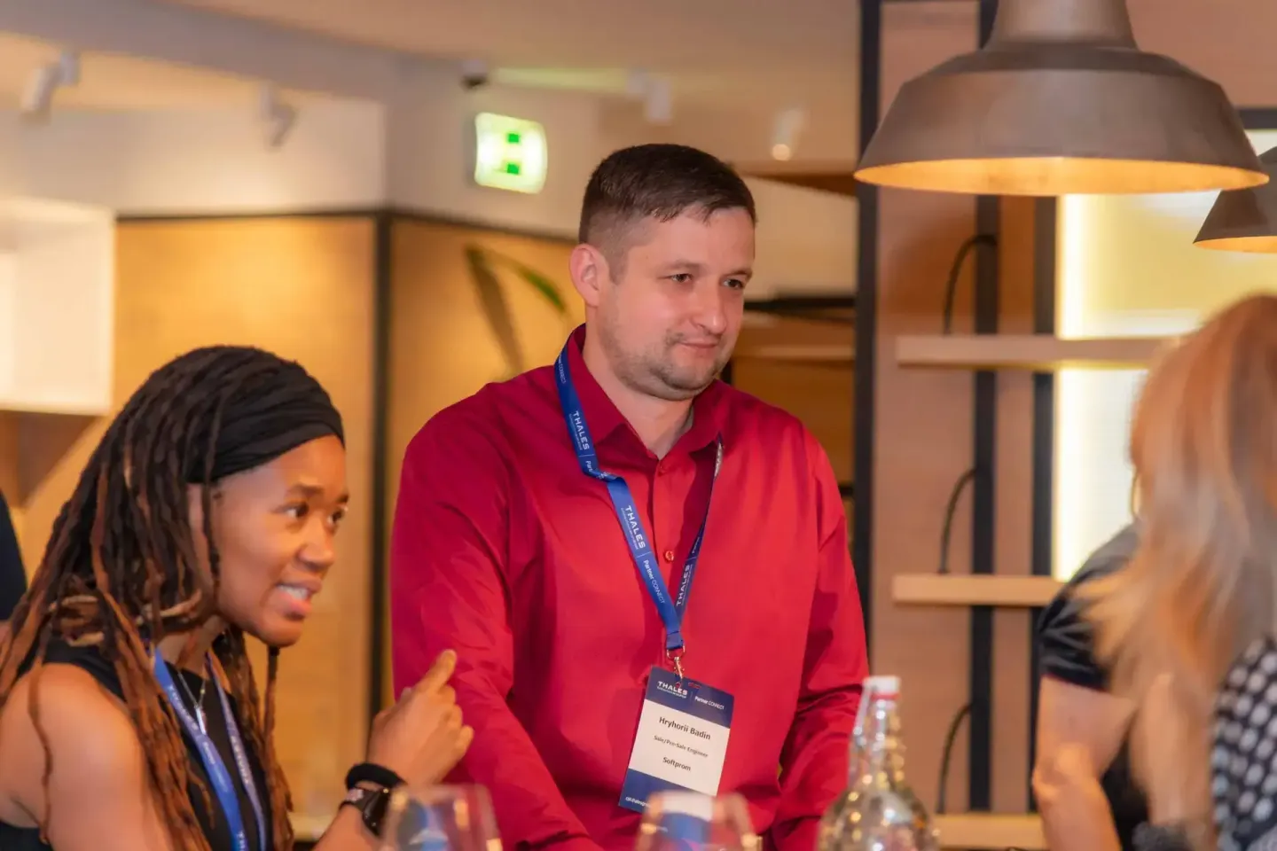 Eventfotograf dokumentiert Diskussion zwischen drei Personen bei Thales Firmenevent in Wien mit professionellem Ambiente