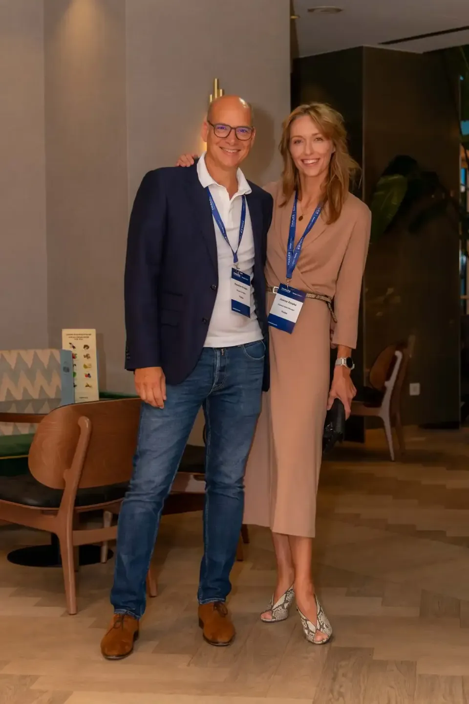 Zwei Personen mit Lanyards auf einem Firmenevent in Wien, lächelnd nebeneinander stehend