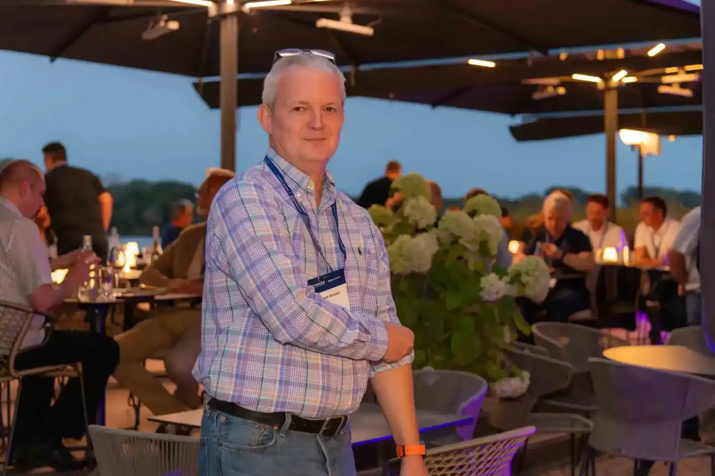 Eventfotograf dokumentiert Gast bei Thales Firmenevent auf Terrasse mit Blick über Landschaft bei Dämmerung