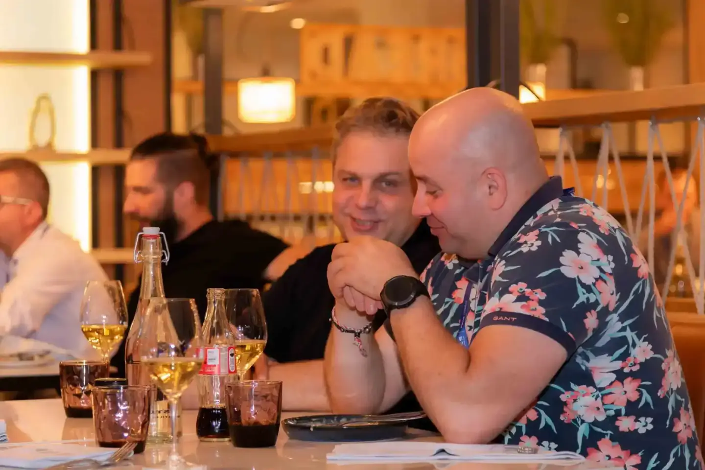 Eventfotograf Wien dokumentiert geselliges Firmenevent mit Gästen beim Networking an gedecktem Tisch mit Weingläsern