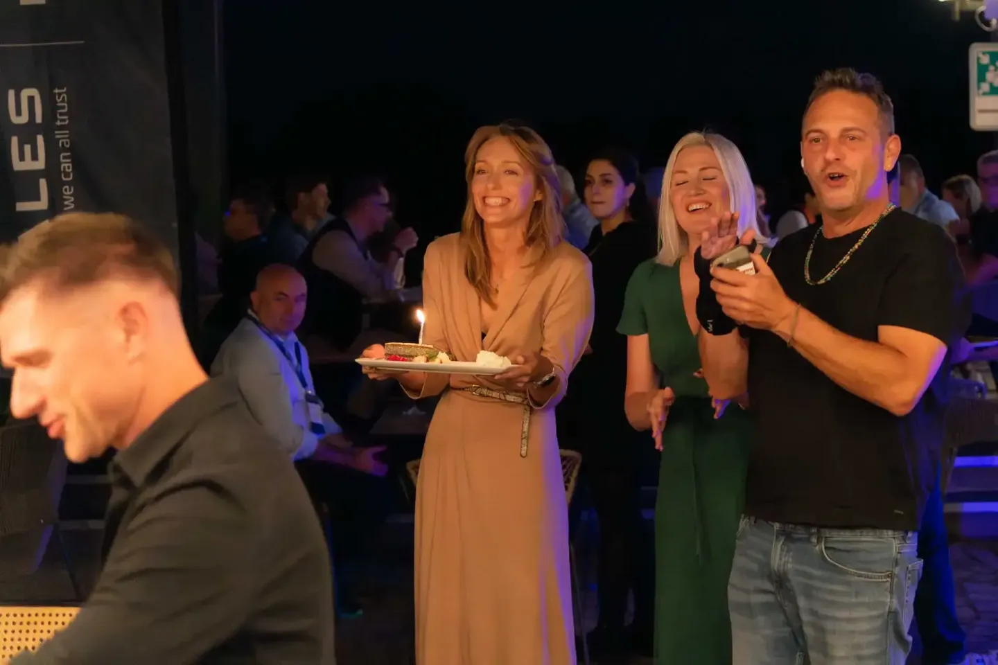 Eventfotografie Wien: Gäste bei einer Firmenveranstaltung feiern mit Kuchen und Getränken in entspannter Atmosphäre