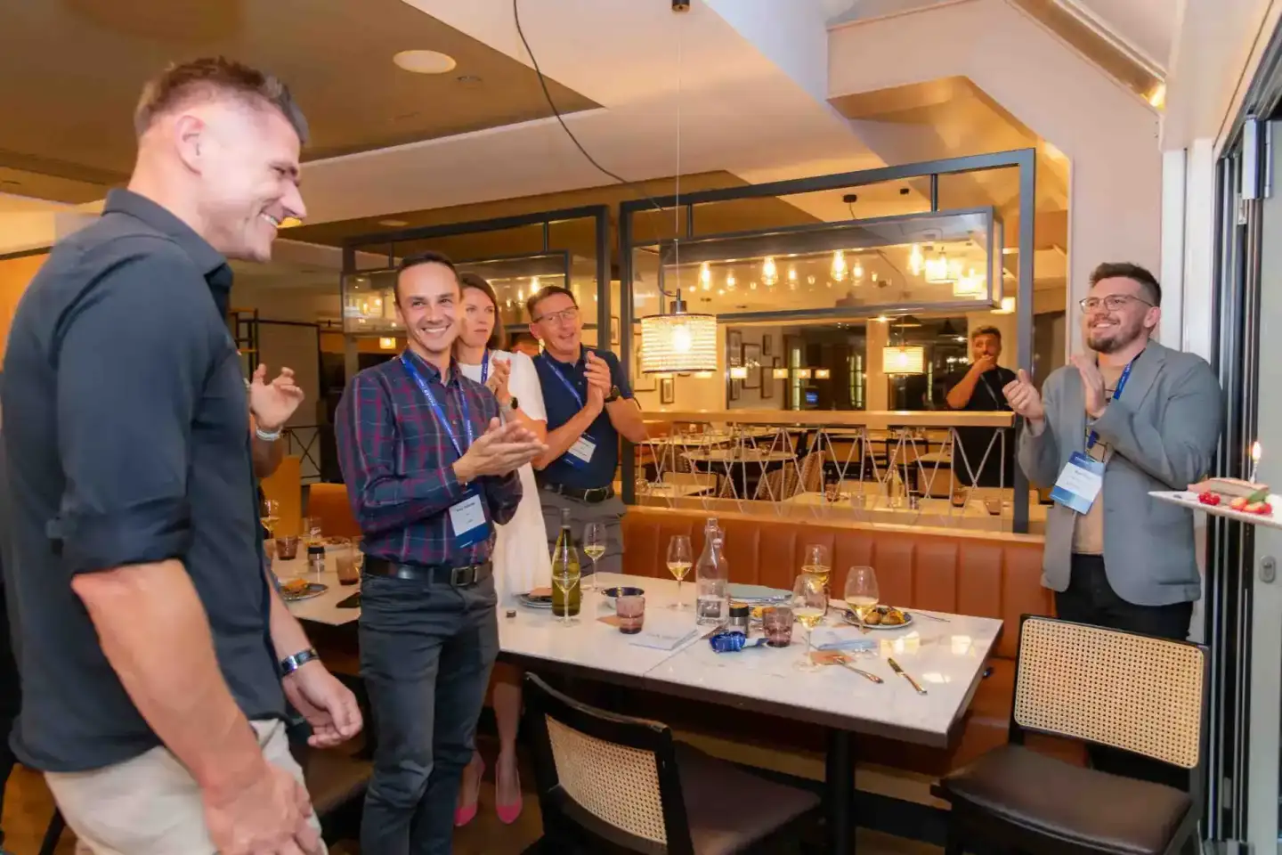 Gruppenfoto von Geschäftsleuten beim Thales Firmenevent Wien mit Networking und Gesprächen am Tisch