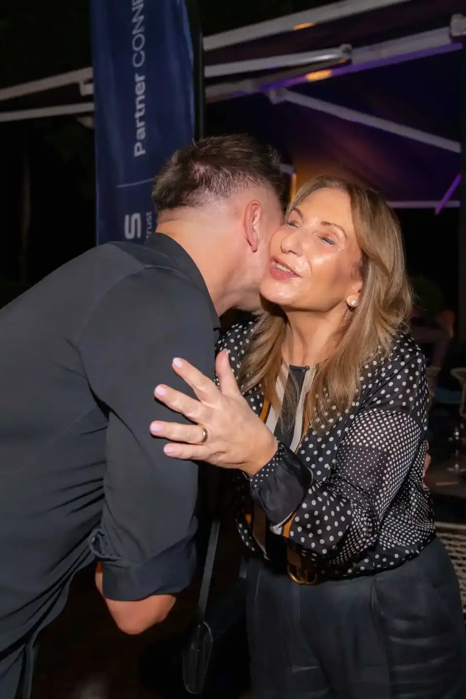 Zwei Personen beim herzlichen Gespräch auf einem Firmenevent Wien, im Hintergrund moderne Event-Dekoration