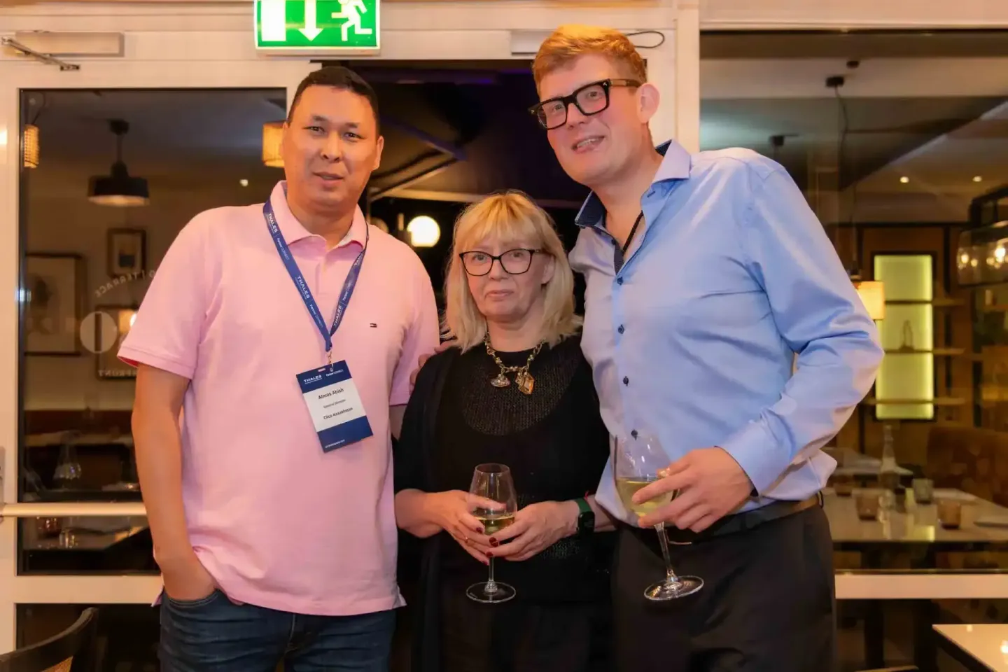 Drei Personen beim Thales Firmenevent in Wien - ein Eventfotograf dokumentiert die gesellige Atmosphäre mit Getränken