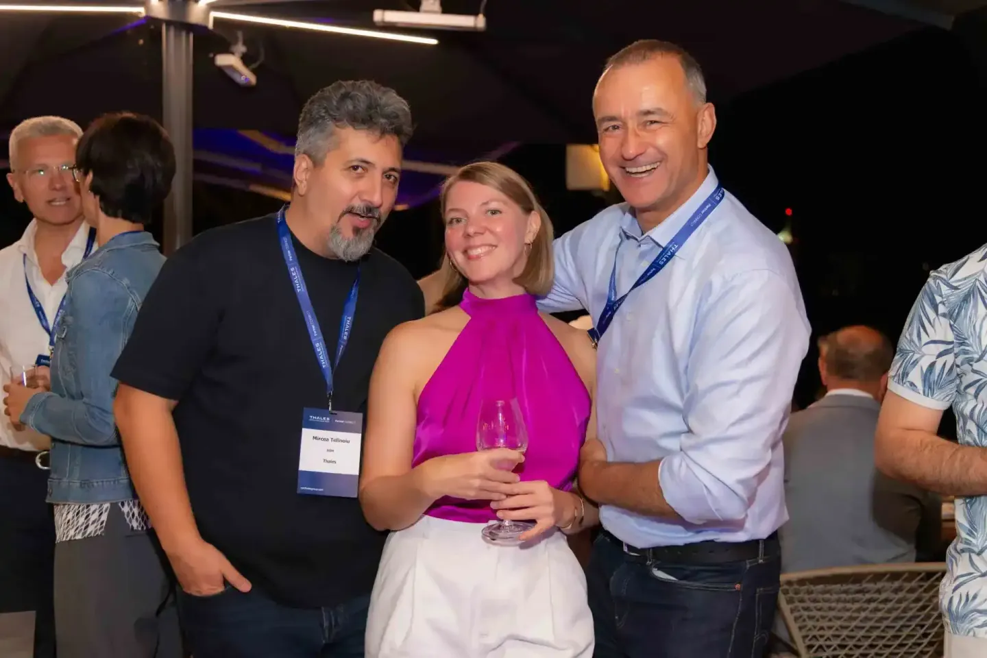 Vier Personen beim Thales Firmenevent in Wien - Mann in schwarzem Shirt mit Namensschild im Gespräch mit Frau in pinkem Obert