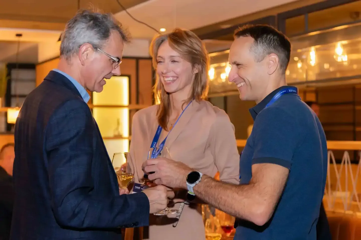 Drei Personen im Gespräch bei einem Firmenevent Wien mit Getränken in eleganter Veranstaltungslocation