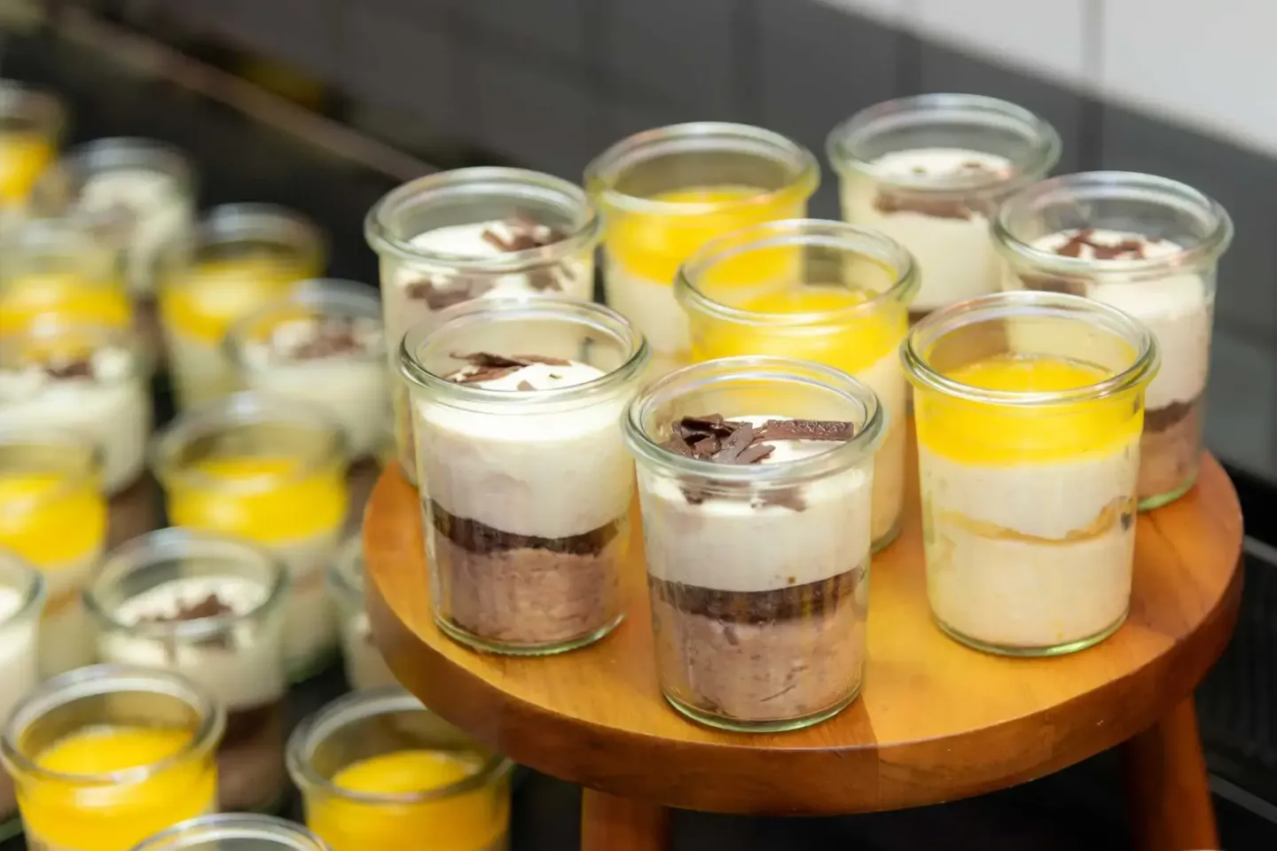 Elegante Desserts in Gläsern bei einem Firmenevent Wien - Schokoladenmousse mit Sahne und gelber Creme als raffinierte Süßspe