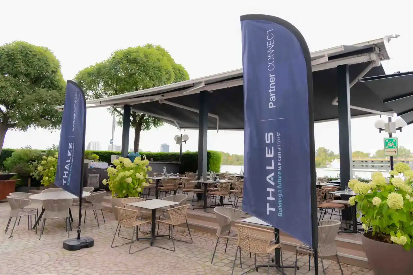 Modernes Eventgelände mit Thales-Branding, Terrassenbereich mit Bestuhlung und Blick auf Wasser - Eventfotografie Wien