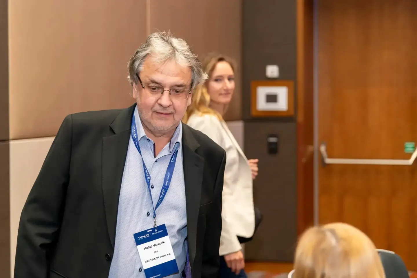 Geschäftsmann mit Thales-Badge auf Firmenevent Wien in modernem Konferenzraum