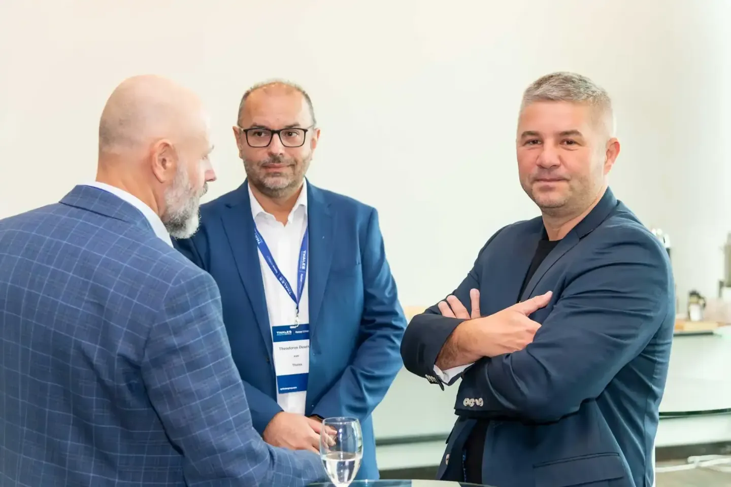 Drei Geschäftsmänner im Gespräch bei einer Thales-Veranstaltung – professionelle Eventfotografie Wien