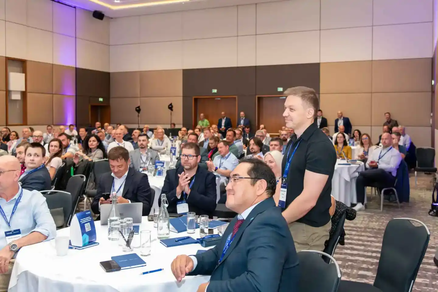 Eventfotograf dokumentiert Konferenzveranstaltung mit Redner vor großem Publikum im modernen Veranstaltungssaal