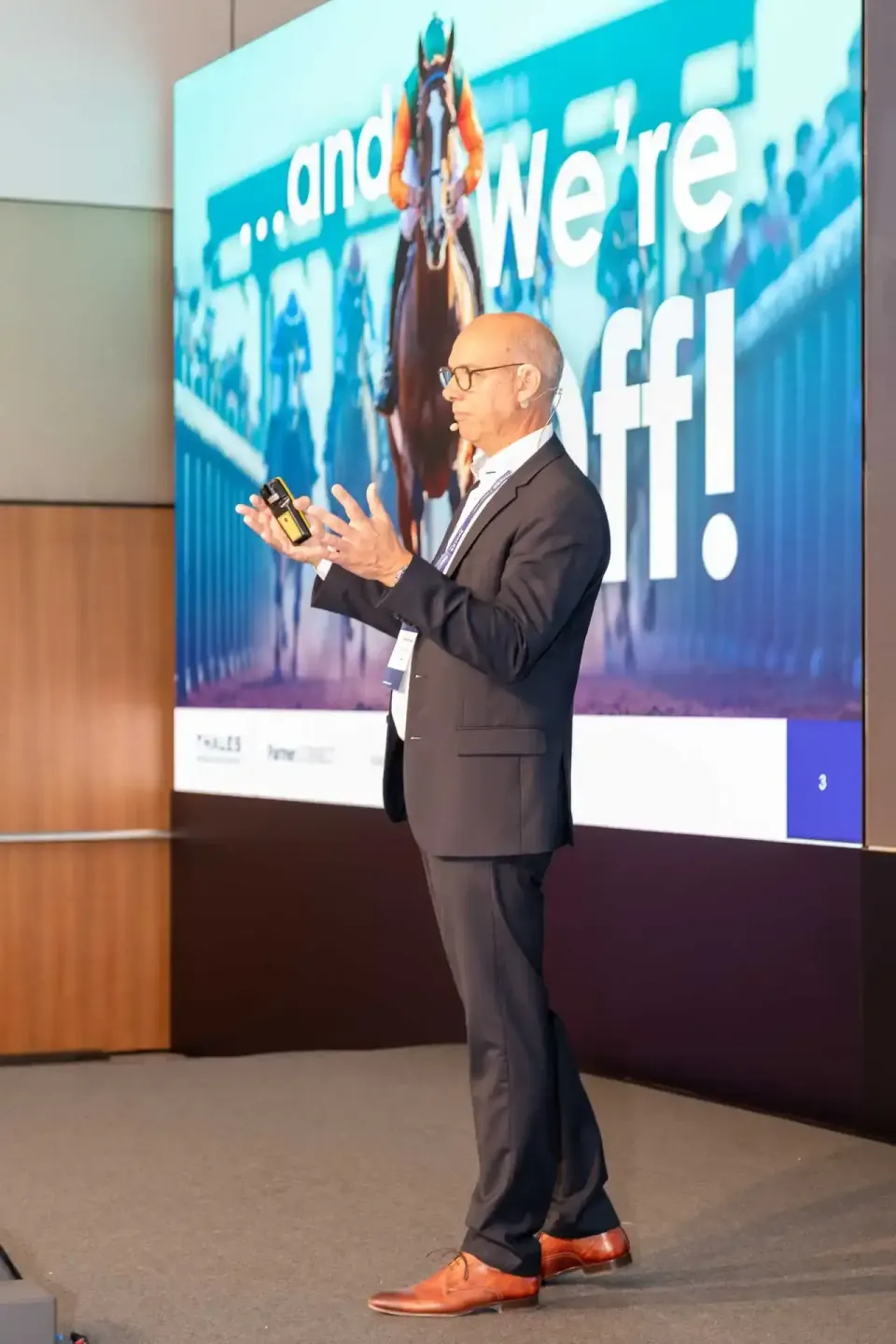 Geschäftsmann präsentiert auf Firmenevent Wien vor großem Display mit Thales-Logo