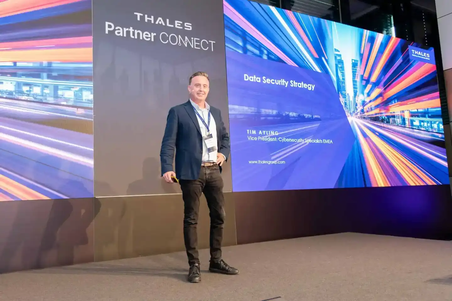Eventfotograf Wien dokumentiert Thales Partner Connect Konferenz mit Redner Tim Ayling vor großem Display zum Thema Data Secu