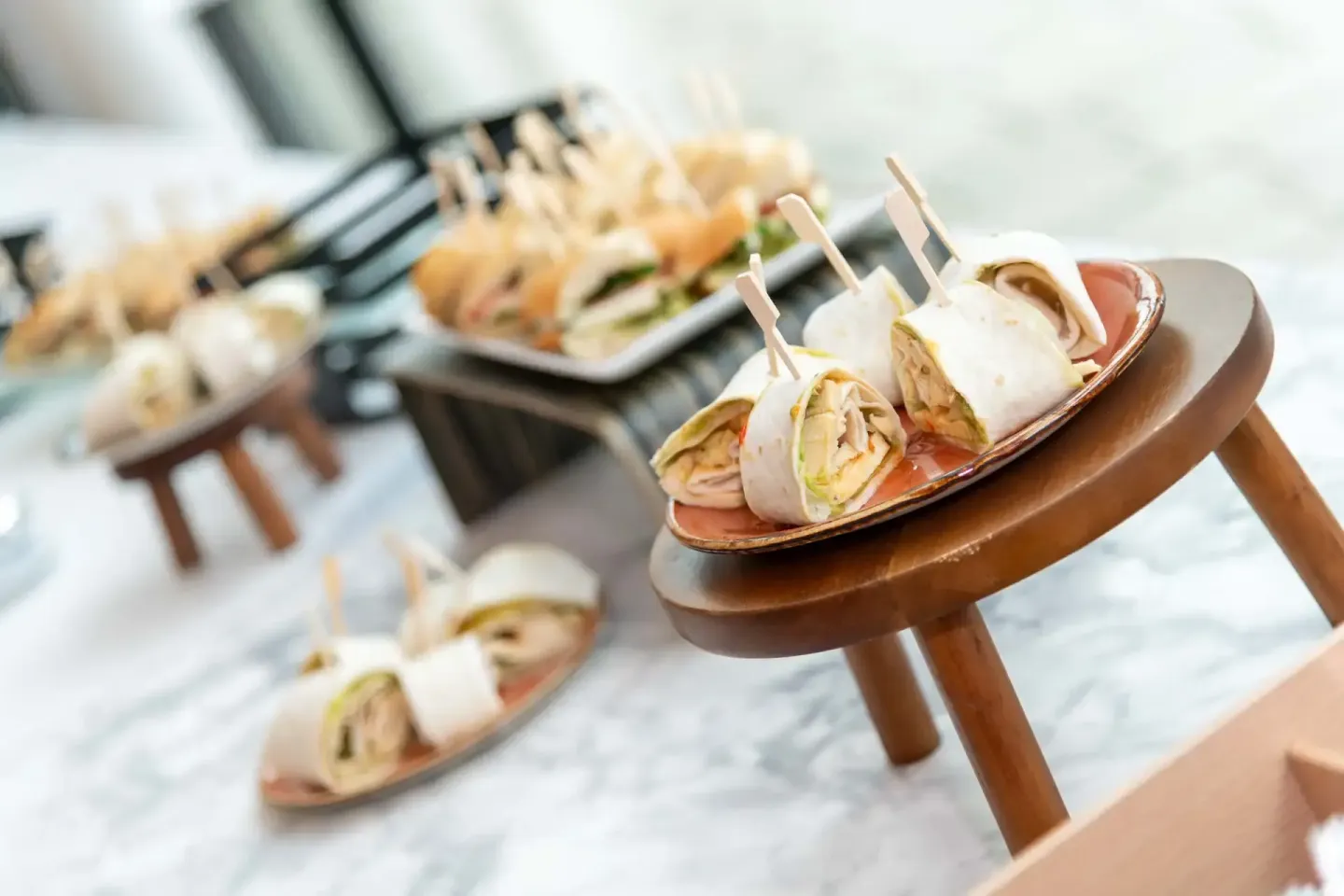 Elegante Catering-Spieße mit Putenfleisch und Frischkäse auf Holzplatte bei Firmenevent Wien