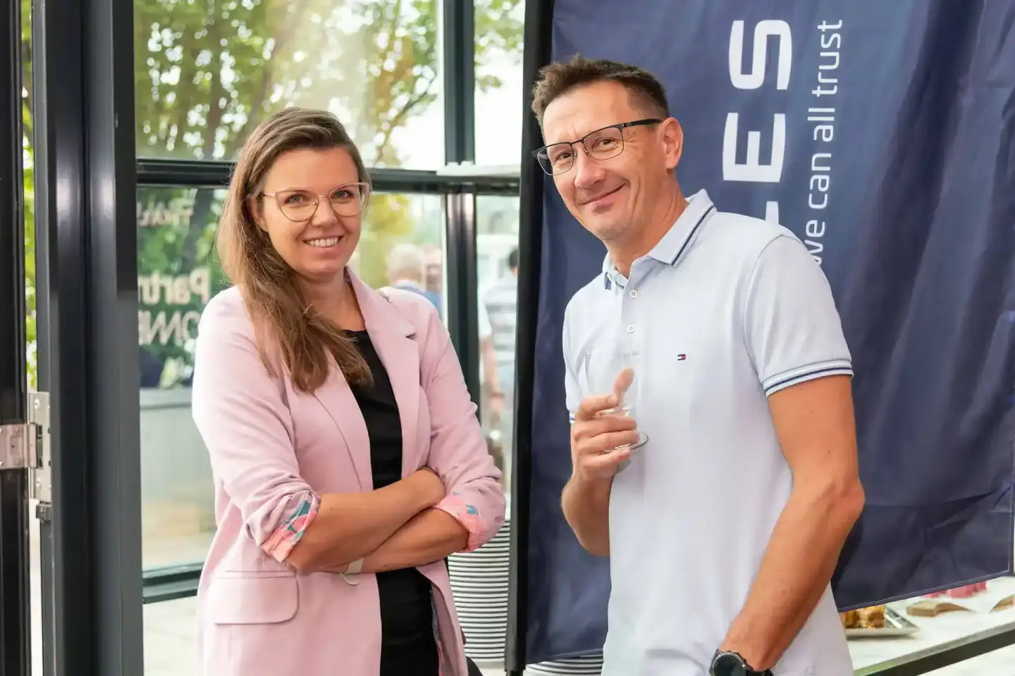 Zwei Personen bei einem Firmenevent Wien präsentieren sich vor einer Bühne mit Unternehmenslogo