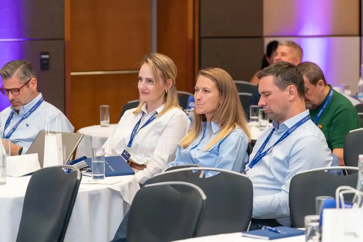 Professionelle Eventfotografie Wien: Teilnehmer bei Thales Firmenveranstaltung sitzen an Konferenztisch mit Namensschildern