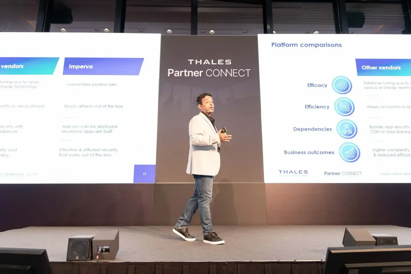 Sprecher präsentiert auf der Bühne die Thales Partner CONNECT Plattform mit Vergleichsfolien im Hintergrund bei einem Firmene