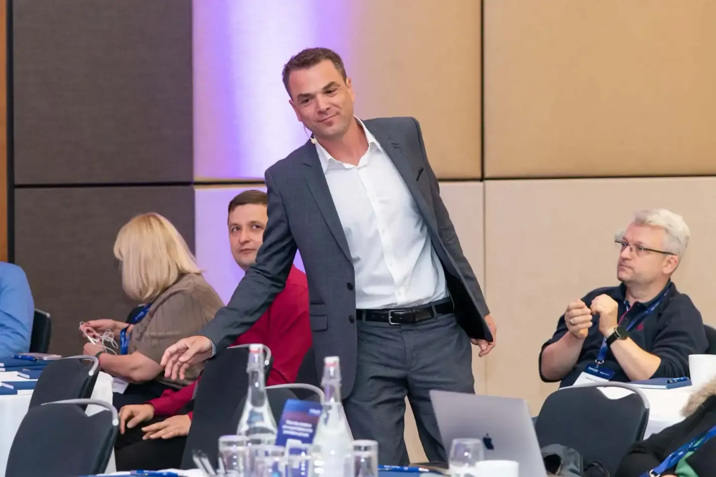 Eventfotograf Wien dokumentiert Geschäftsmann bei Präsentation auf Thales Firmenveranstaltung mit Teilnehmern am Tisch