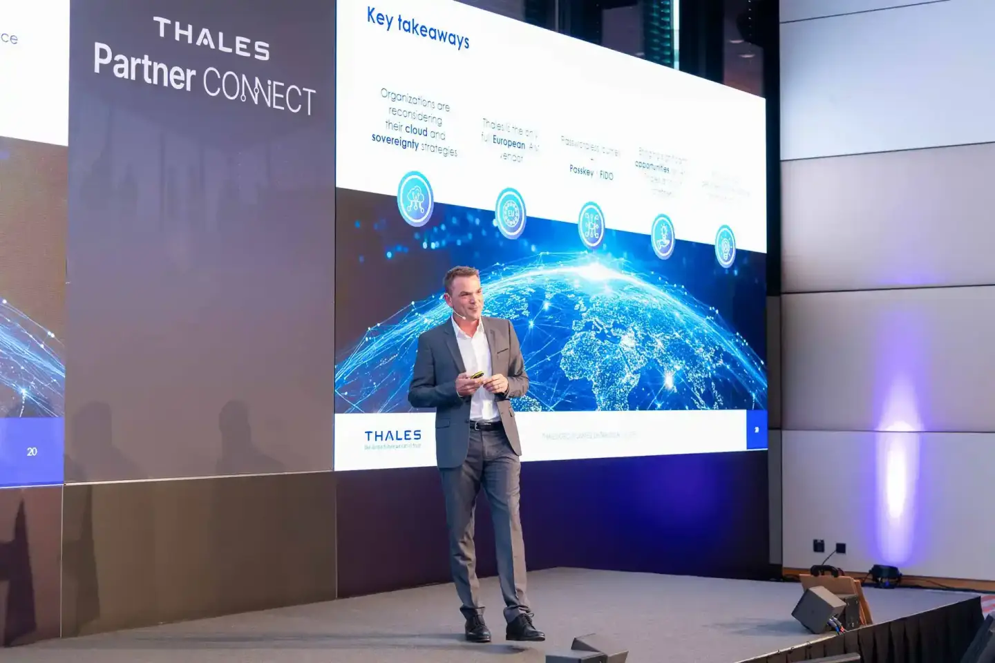 Geschäftsmann präsentiert bei Thales Partner Connect Event vor digitalem Globus auf großem Display - professionelle Eventfoto