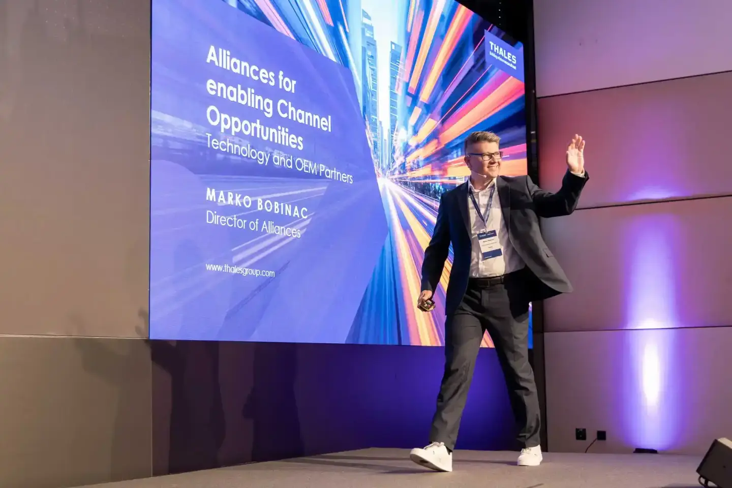 Eventfotograf dokumentiert Geschäftsmann bei Präsentation auf Thales Konferenz mit Vortragsbühne und LED-Wand