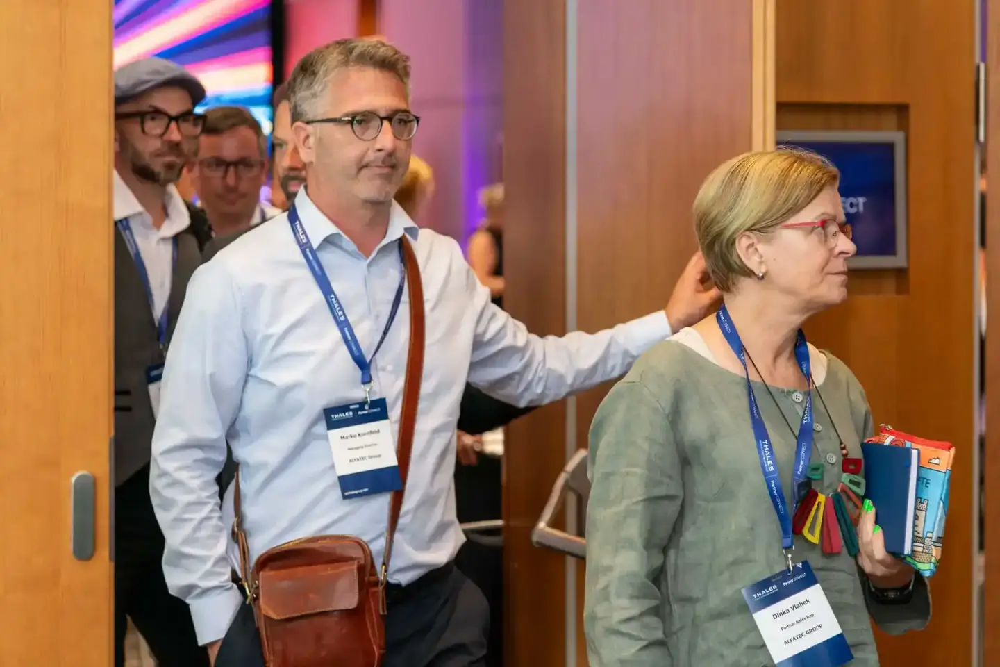 Eventfotografie Wien: Teilnehmer mit Lanyards bei einer Thales-Konferenz in modernem Veranstaltungsraum