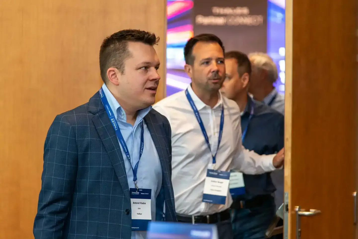 Eventfotograf Wien dokumentiert Geschäftsmänner mit Namensschildern bei Thales Firmenevent in eleganter Veranstaltungshalle