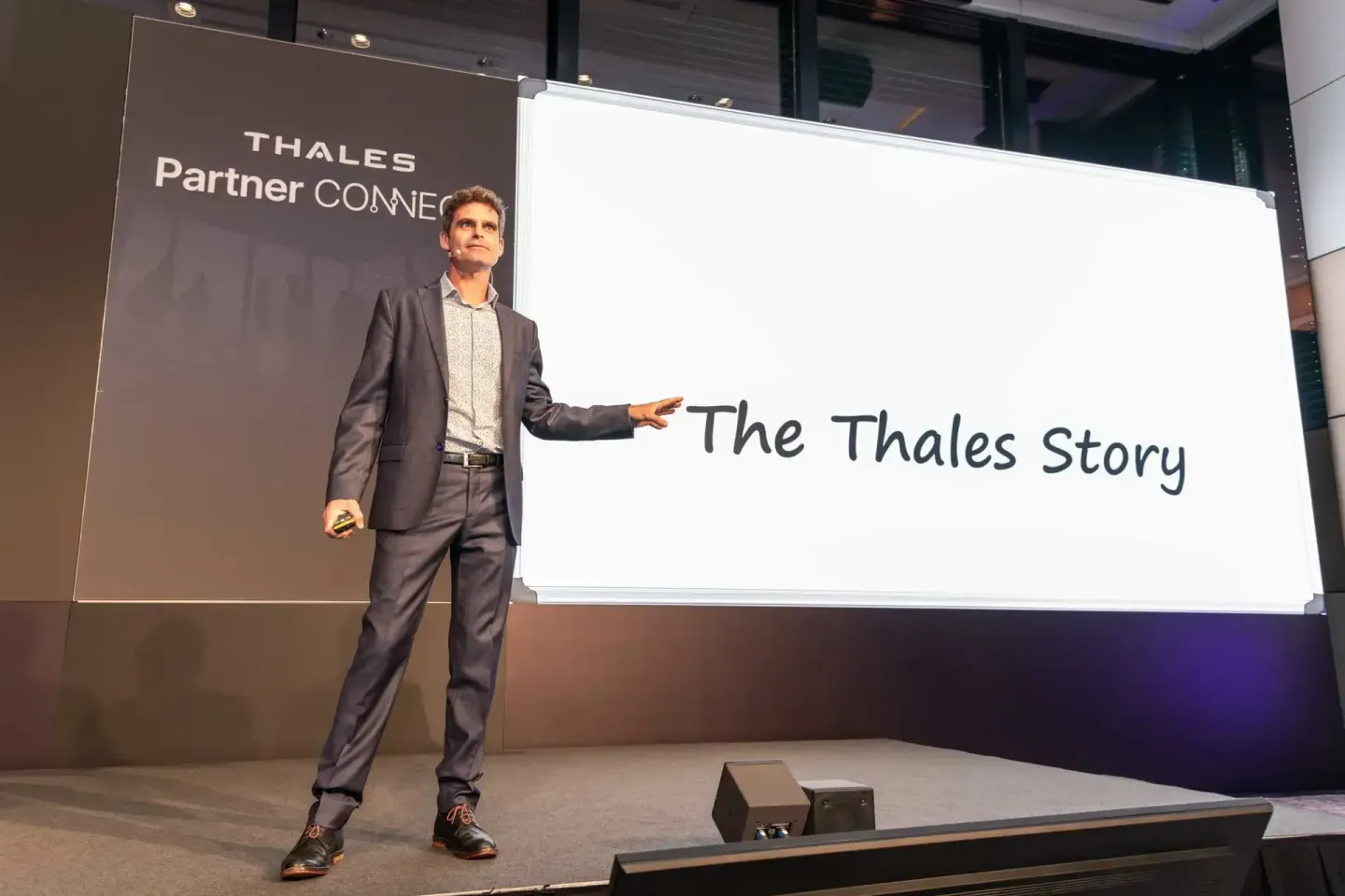 Geschäftsmann präsentiert auf der Bühne zur Thales Partner Connect Veranstaltung - Eventfotografie Wien