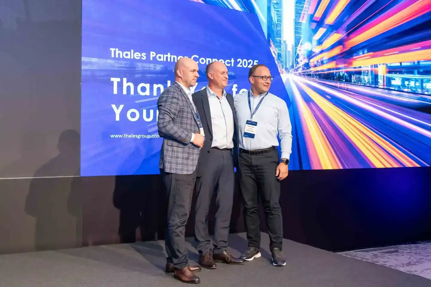 Drei Geschäftsleute auf der Bühne der Thales Partner Connect 2025 Konferenz – Eventfotografie Wien