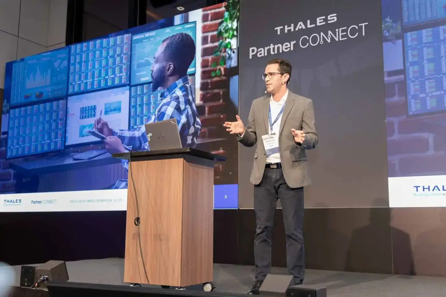 Eventfotograf dokumentiert Präsentation bei Thales Partner Connect Konferenz mit Redner am Podium