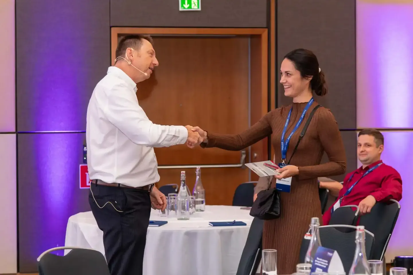 Eventfotograf Wien dokumentiert Geschäftsleute beim Handschlag auf Firmenevent mit Konferenzteilnehmern