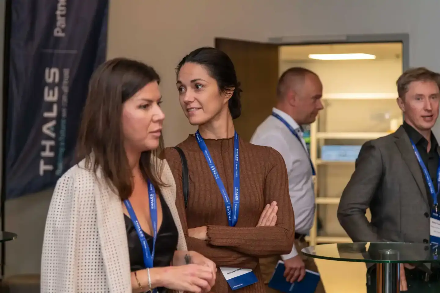 Profesionelle Eventfotografie Wien: Teilnehmer mit Lanyards beim Thales Firmenevent im modernen Konferenzraum