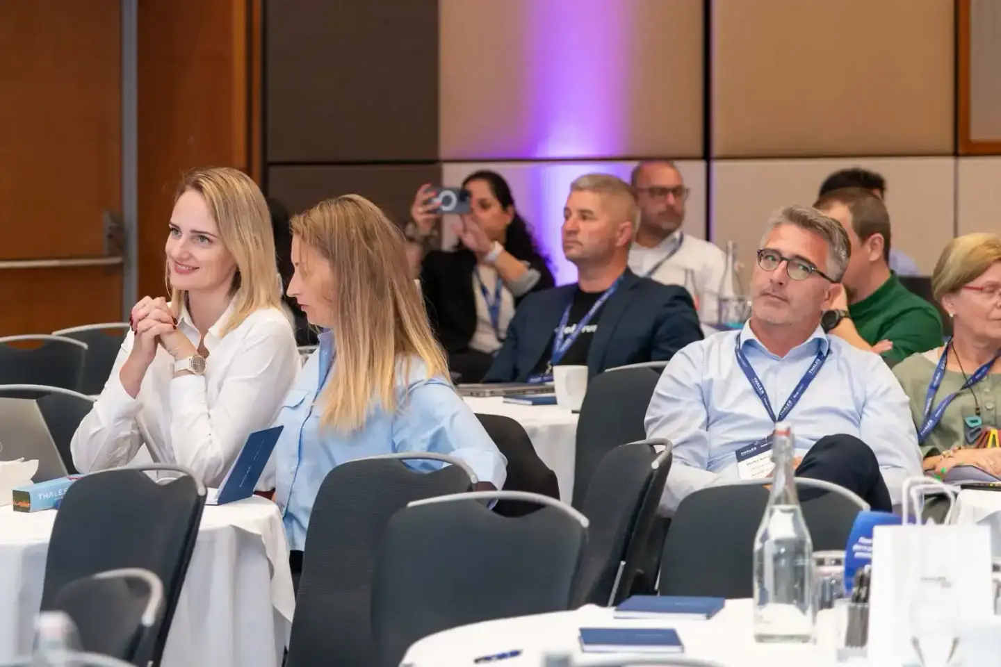 Teilnehmer eines Firmenevents von Thales sitzen aufmerksam in einem modernen Konferenzraum – professionelle Eventfotografie W