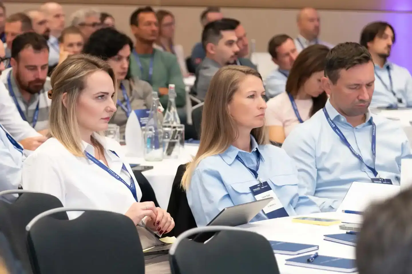 Teilnehmer einer Thales-Konferenz sitzen aufmerksam am Tisch, Eventfotografie Wien dokumentiert die professionelle Veranstalt