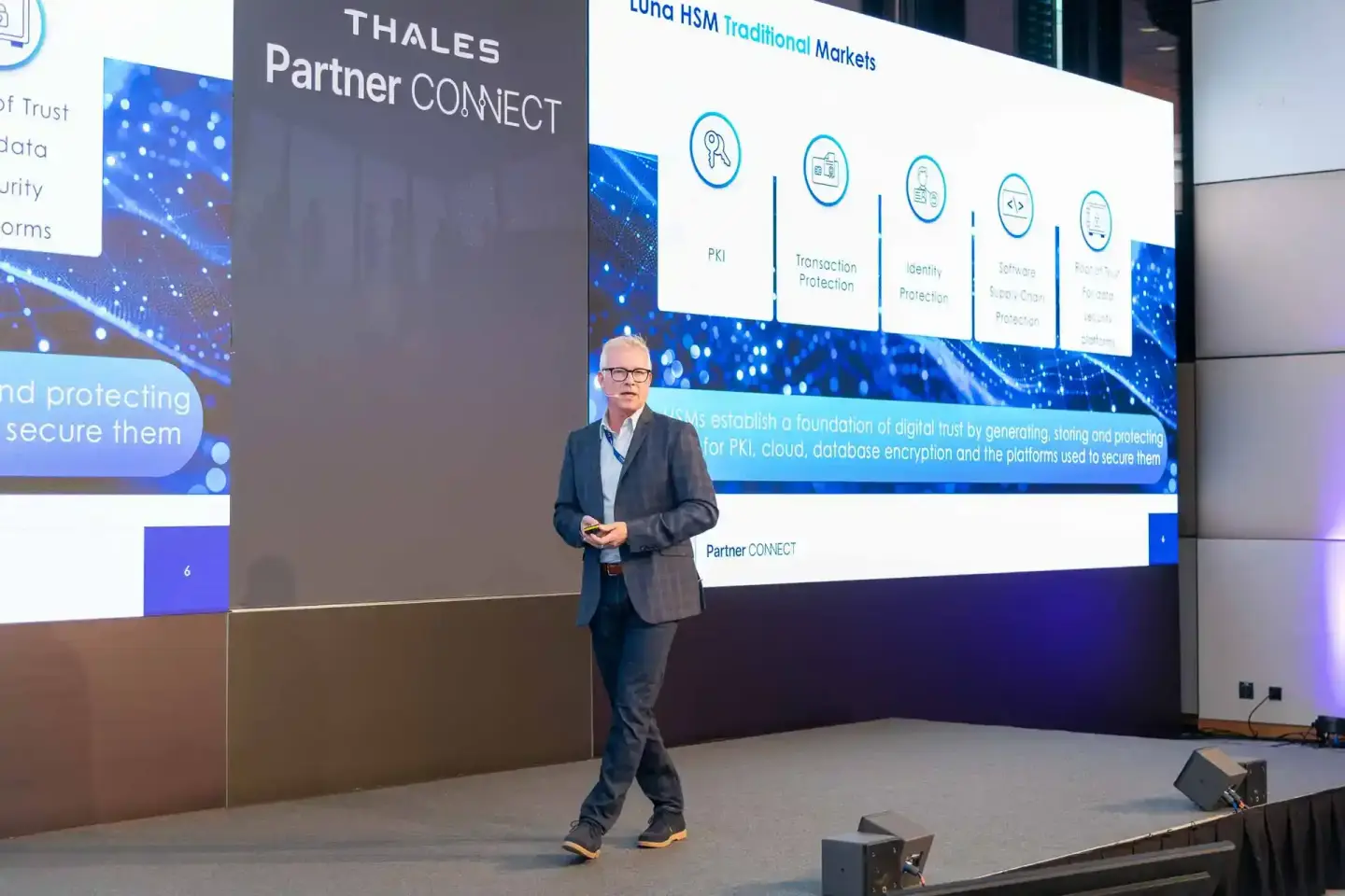 Vortragender präsentiert Thales Partner Connect Lösung bei Firmenevent Wien auf großer Bühne mit digitalen Sicherheitsicons