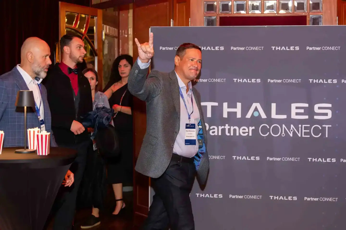 Eventfotograf dokumentiert Geschäftsleute beim Thales Partner Connect Event in Wien vor Unternehmensbackdrop