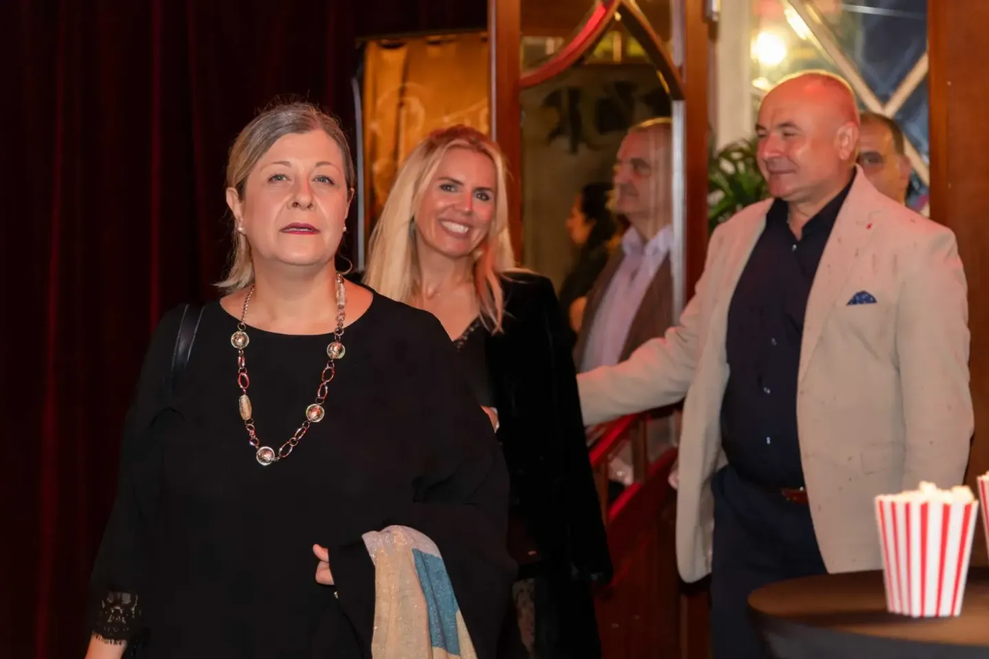 Gäste beim Thales Firmenevent in Wien - Eventfotograf dokumentiert die Veranstaltung mit eleganten Besuchern vor rotem Vorhan