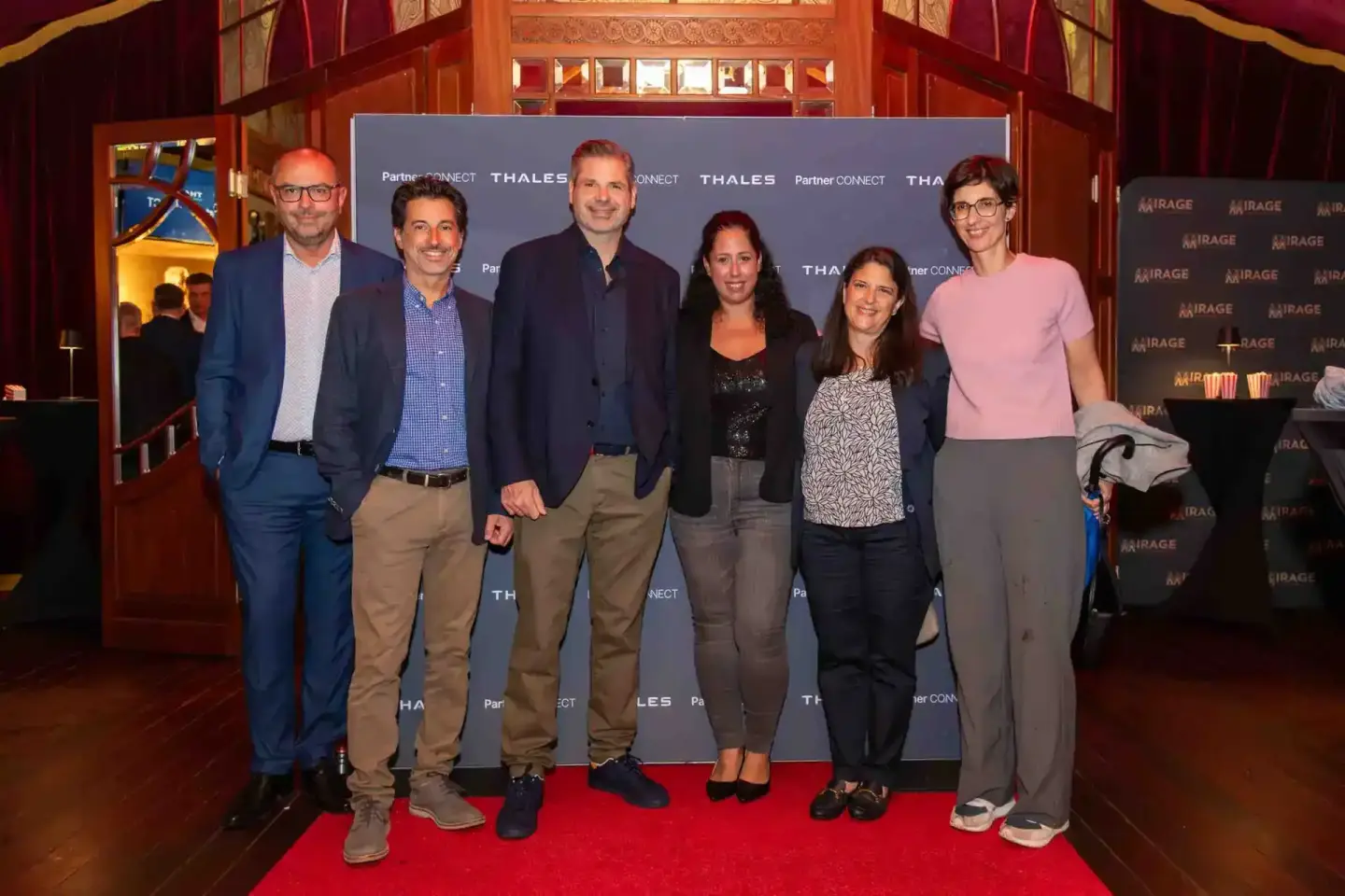 Sechs Personen posieren vor Thales und Partner Connect Bannern auf rotem Teppich bei Firmenevent Wien