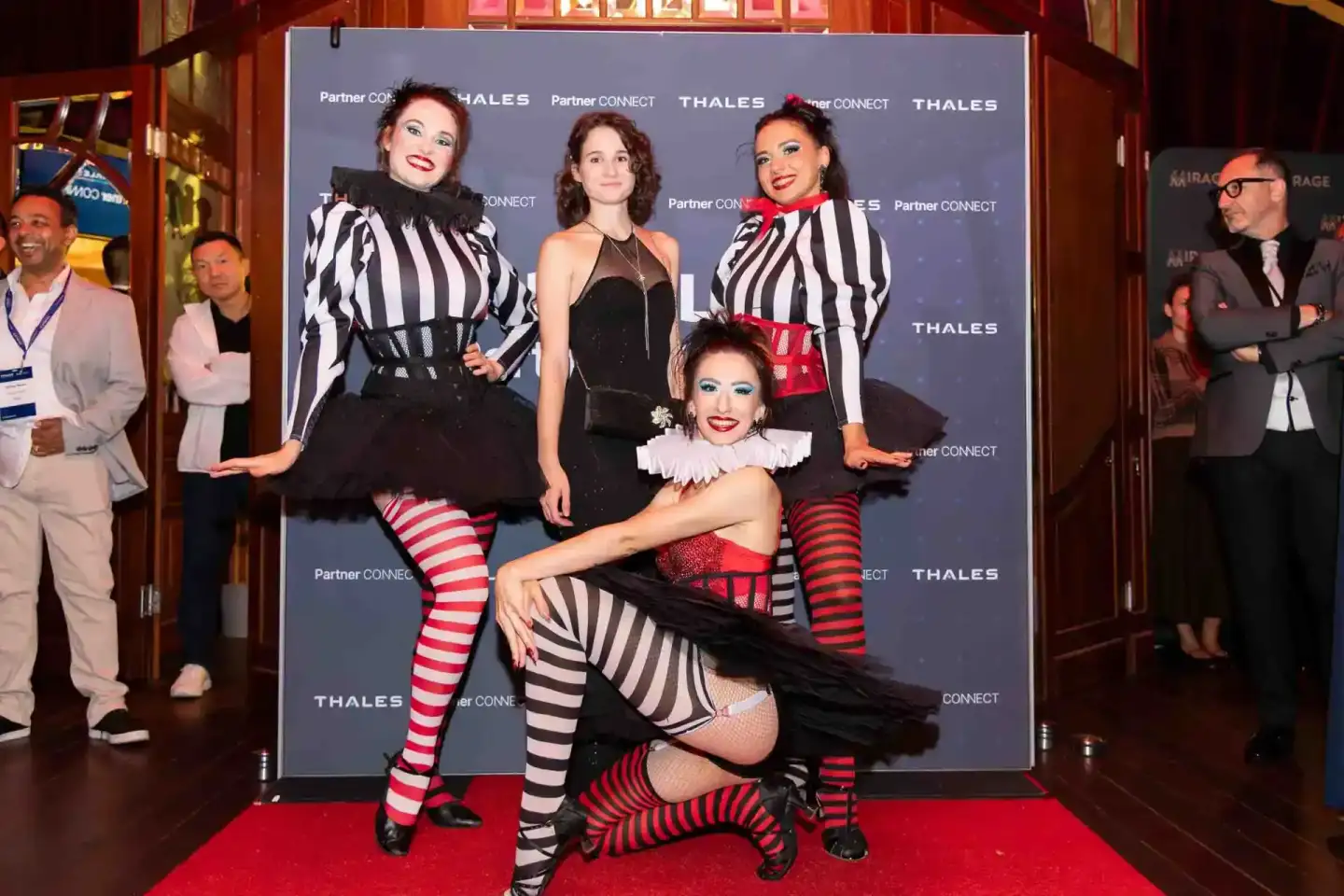 Vier Performerinnen in schwarz-weißen und roten Streifenkostümen beim Thales Firmenevent Wien