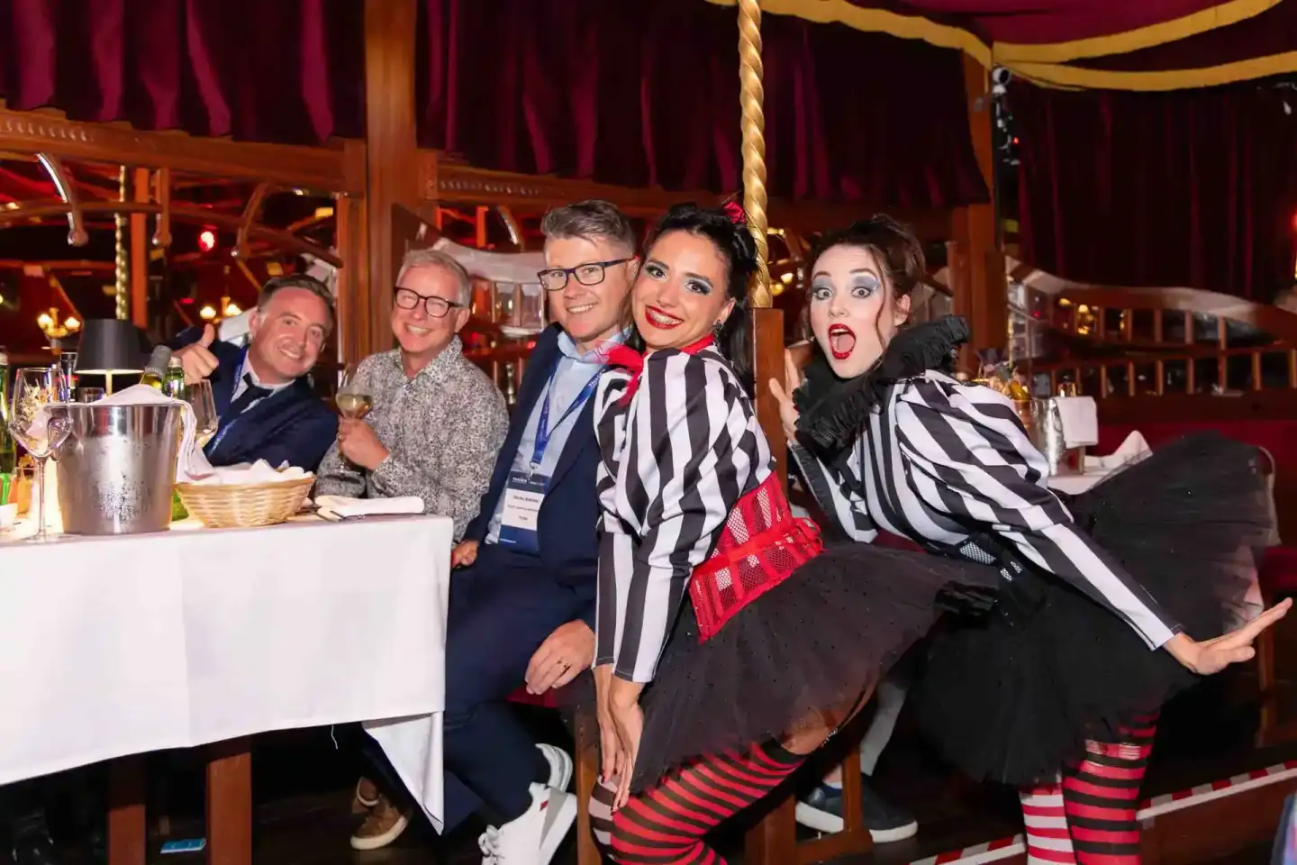 Fünf Personen posieren lachend an einem elegantly gedeckten Tisch beim Thales Firmenevent, professionelle Eventfotografie Wie