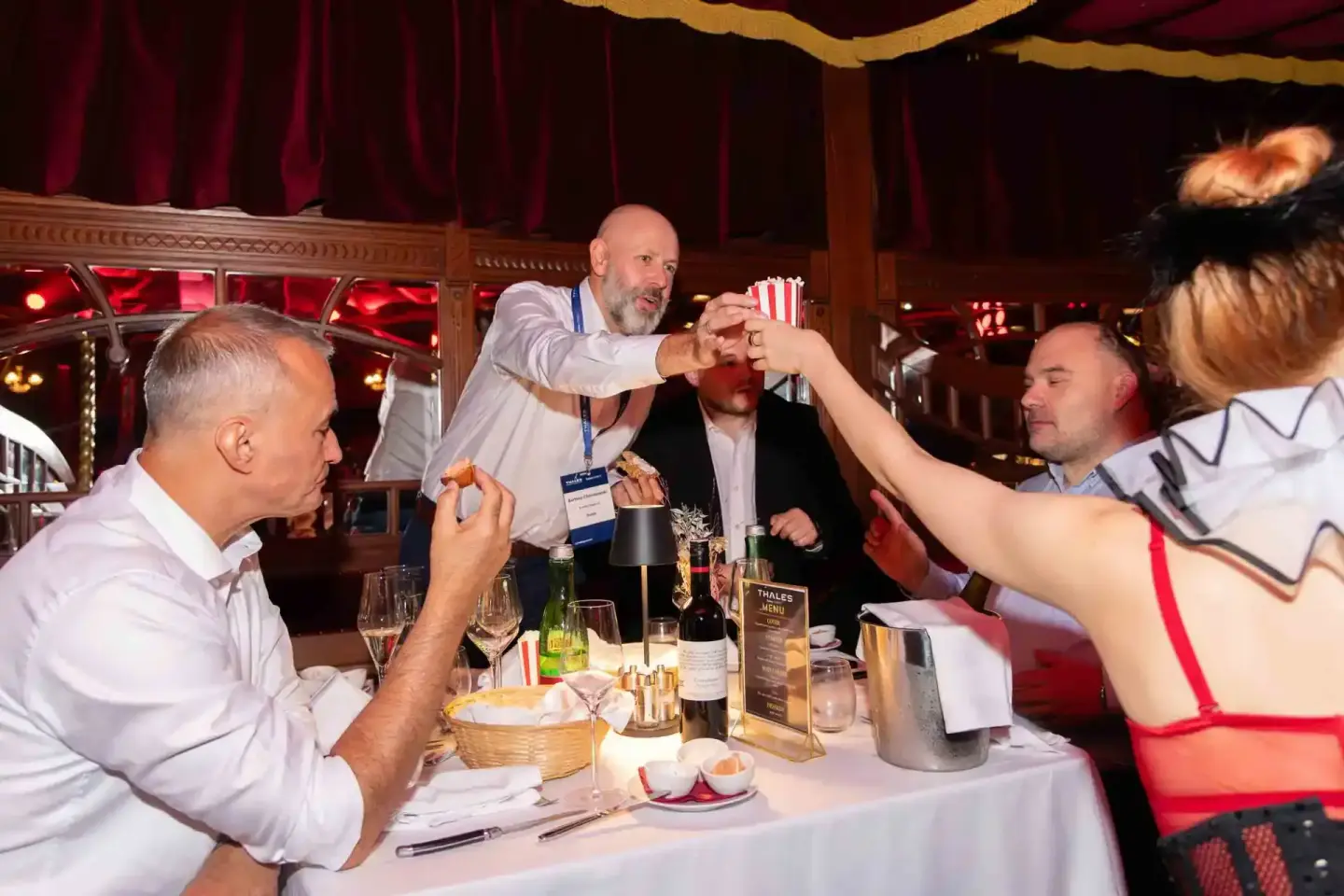 Gäste beim Thales Firmenevent in Wien genießen gemeinsam Popcorn und Getränke an einem elegant gedeckten Tisch