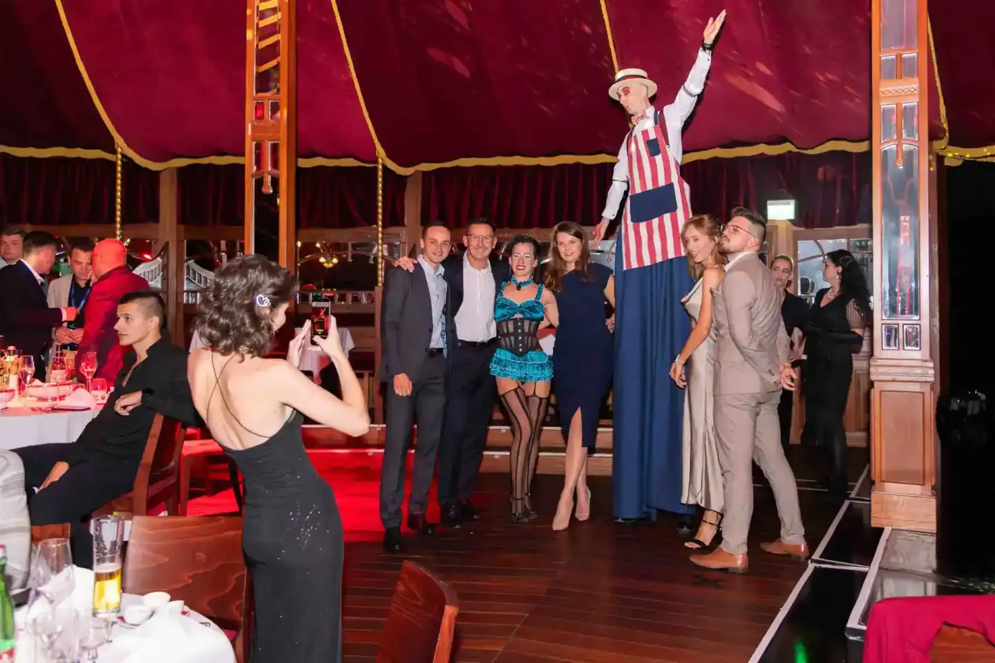 Eventfotograf Wien dokumentiert Firmenevent in Zirkuszelt mit eleganten Gästen und Performer auf Podium